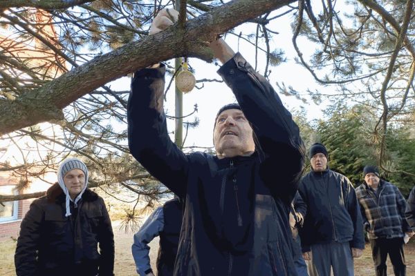 Mieszkaniec wiesza pokarm dla ptaków.