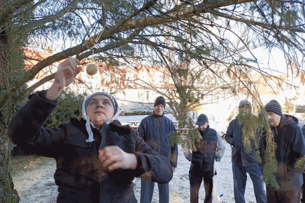 Mieszkaniec wiesza pokarm dla ptaków.