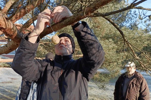 Mieszkaniec wiesza pokarm dla ptaków.