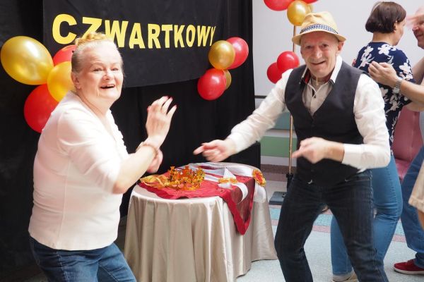 Mieszkańcy tańczą na holu podczas balu.