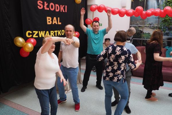Mieszkańcy tańczą na holu podczas balu.