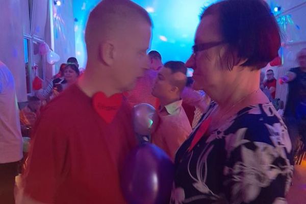 Mieszkańcy wraz z innymi uczestnikami zabawy tańczą z balonem na sali w Przytocku.