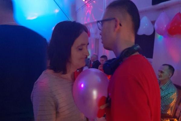 Mieszkańcy wraz z innymi uczestnikami zabawy tańczą z balonem na sali w Przytocku.