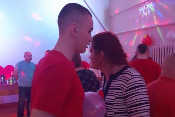 Mieszkańcy wraz z innymi uczestnikami zabawy tańczą z balonem na sali w Przytocku.