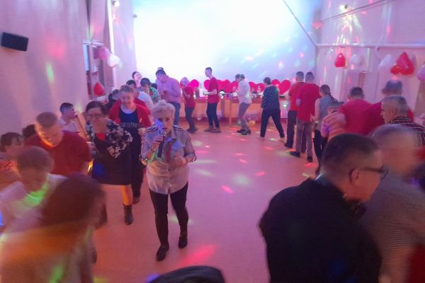 Mieszkańcy wraz z innymi uczestnikami zabawy tańczą i śpiewają na sali w Przytocku.