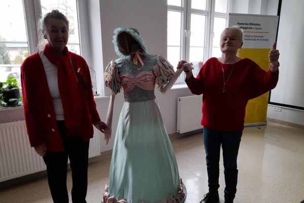Dwie mieszkanki przy manekinie w sukni z XIX w.