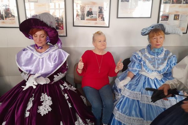 Mieszkanka wraz z Paniami w sukniach z XIXw.