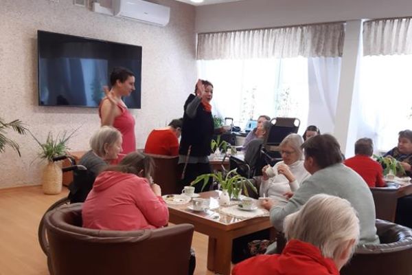 Mieszkanki przy stolikach przy poczęstunku.