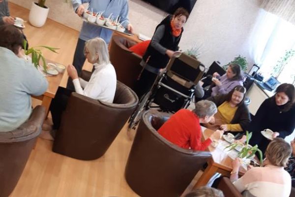 Mieszkanki przy stolikach przy poczęstunku.