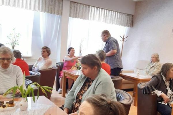 Mieszkanki przy stolikach przy poczęstunku.