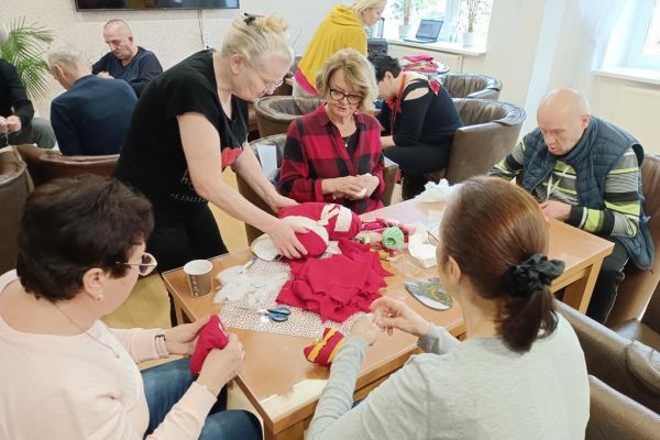 Mieszkańcy wraz z uczestnikami UTW szyją serca z materiału.