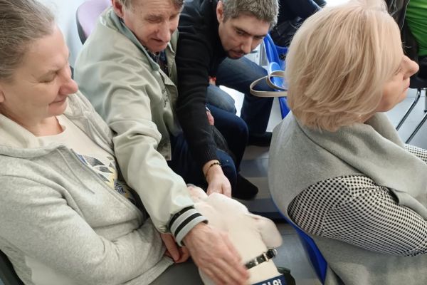 Dwoje mieszkańców głaska psa.