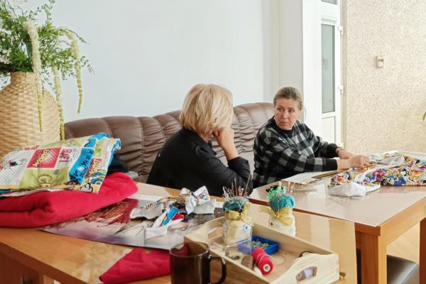 Dwie uczestniczki UTW w Redzikowie kroją materiał.