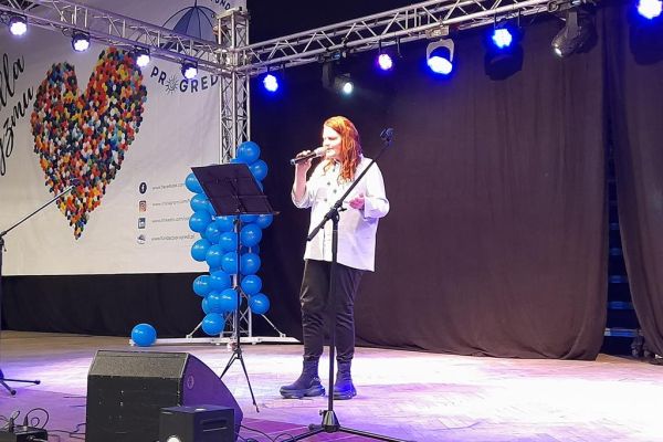 Mieszkanka śpiewa na scenie podczas akcji 'Serce dla autyzmu.