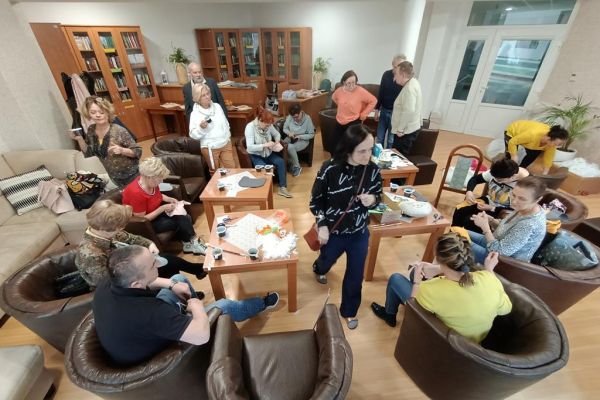 Mieszkańcy wraz z uczestnikami UTW w Redzikowie wycinają wzory z materiału i szyją.