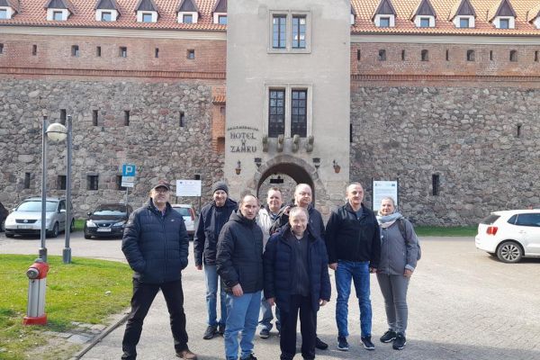 Grupa mieszkańców przed zamkiem w Bytowie.