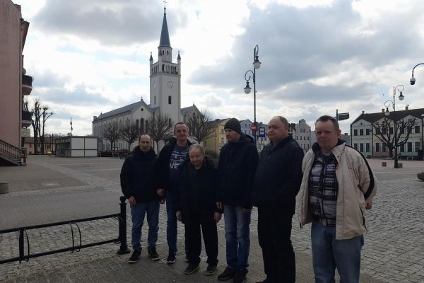 Grupa mieszkańców na na placu przy kościele w Bytowie.