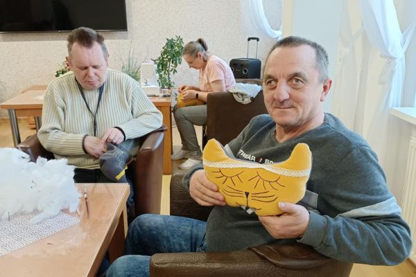 Mieszkaniec trzyma uszytego kota.