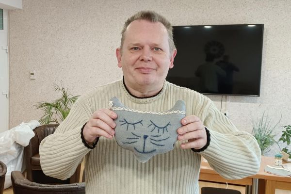 Mieszkaniec trzyma uszytego kota.