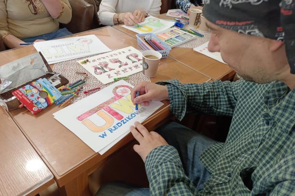 Mieszkańcy wspólnie z uczestnikami UTW z Redzikowa wykonuja atrybuty do kibicowania.