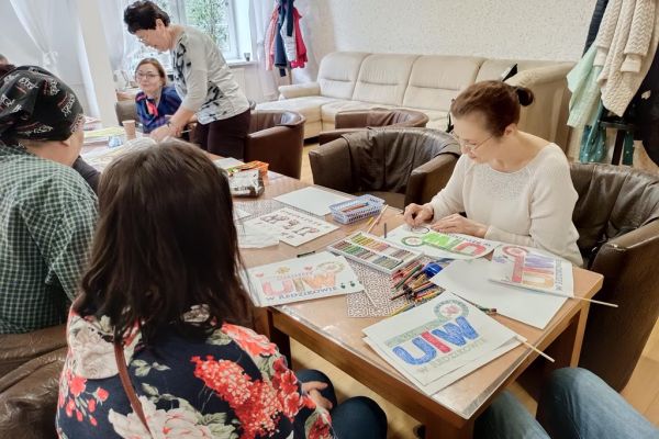 Mieszkańcy wspólnie z uczestnikami UTW z Redzikowa wykonuja atrybuty do kibicowania.