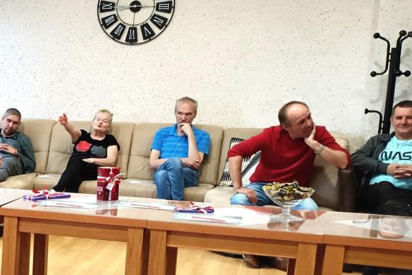 Mieszkańcy siedząc na fotelach uczestniczą w quizie.