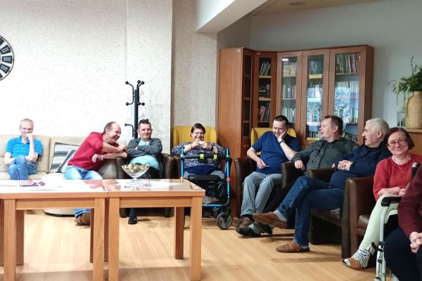 Mieszkańcy siedząc na fotelach uczestniczą w quizie.