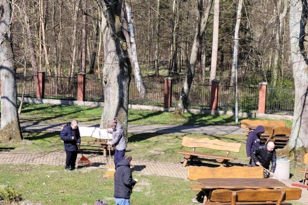 Mieszkańcy grabia i zamiatają teren wokół Domu.