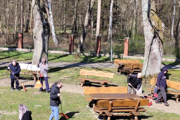 Mieszkańcy grabia i zamiatają teren wokół Domu.
