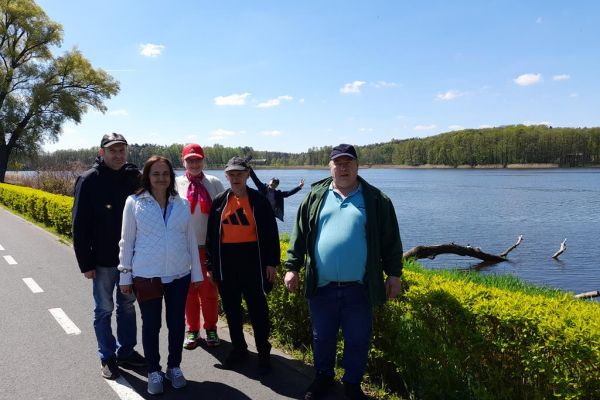 Mieszkańcy zwiedzają Złotów. Stoją przy jeziorze.