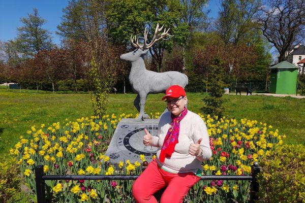 mieszkanka siedzi przy rzeźbie jelenia.