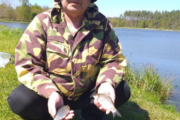 Mieszkaniec trzyma złowione ryby.