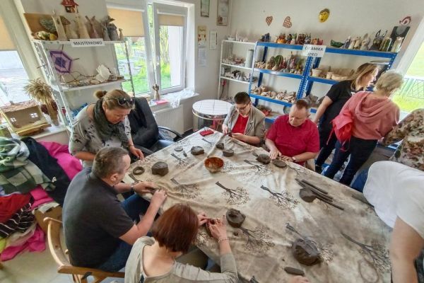 Mieszkańcy wraz z uczestnikami UTW z Redzikowa lepią poidełka z gliny.