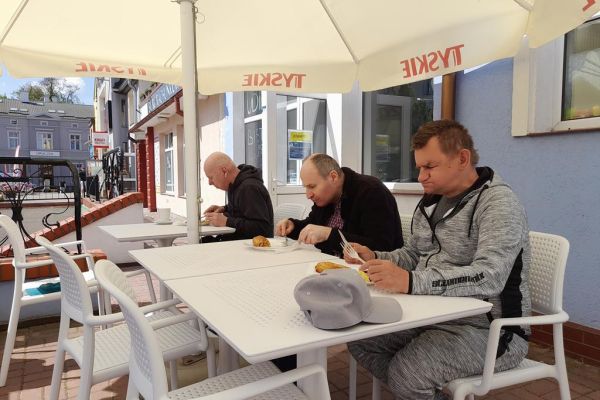 Mieszkańcy zwiedzają Szczecinek, jedzą w restauracji.