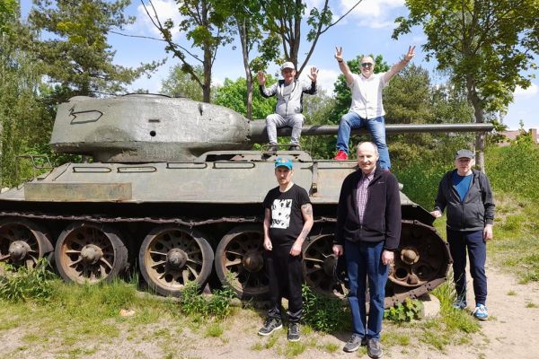 Mieszkańcy zwiedzają Szczecinek, stoją przy i na czołgu.