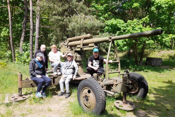 Mieszkańcy zwiedzają Szczecinek, siedzą na armacie, działo z II wojny.