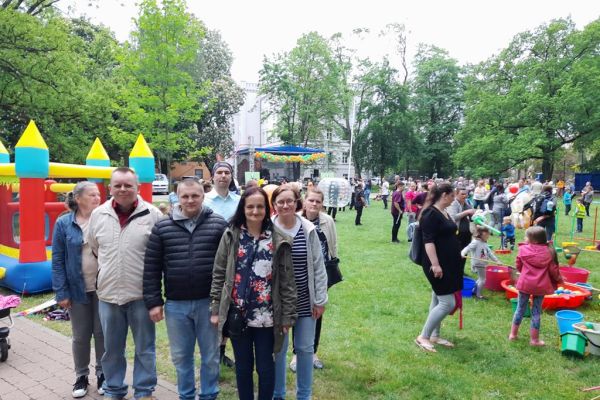 Mieszkańcy w parku w Słupsku podczas Dnia Godności Osób z Niepełnosprawnością Intelektualną stoją w grupowym zdjęciu.