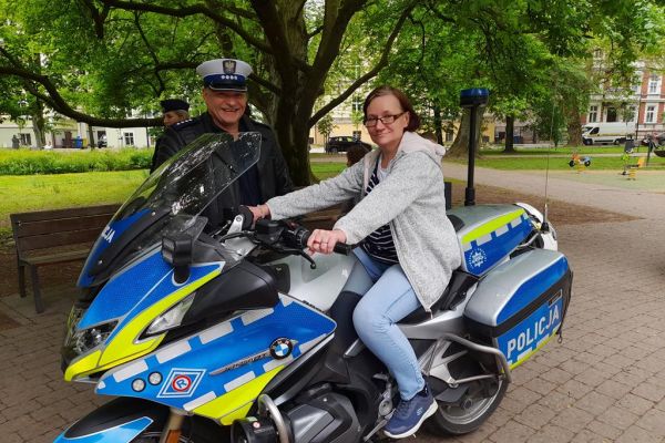 Mieszkanka w parku w Słupsku podczas Dnia Godności Osób z Niepełnosprawnością Intelektualną siedzi na motorze na zdjęciu.