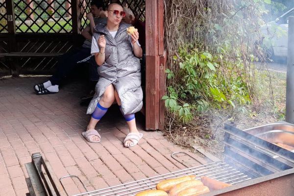 Mieszkanka je kiełbaskę z grilla.