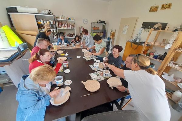 Mieszkańcy wraz z uczestnikami UTW z Redzikowa szkliwią glinę.