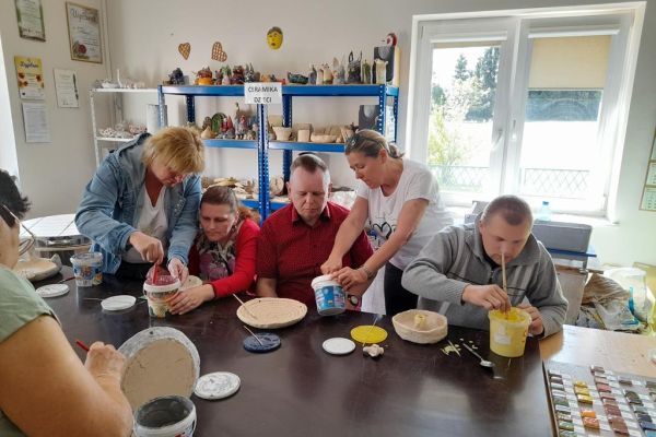 Mieszkańcy wraz z uczestnikami UTW z Redzikowa szkliwią glinę.