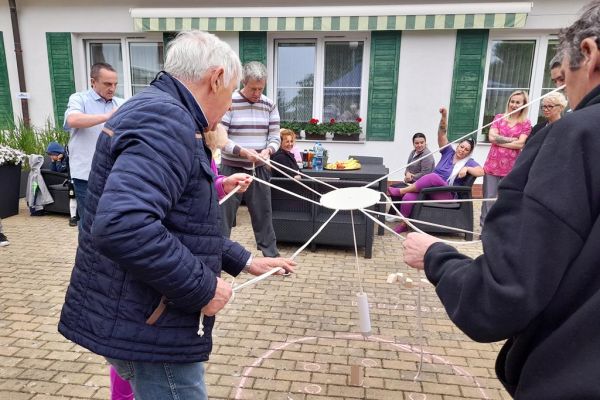Uczestnicy pikniku grają w grę zręcznościową.