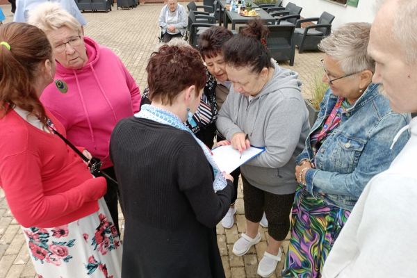 Uczestnicy pikniku grają w grę logiczną.