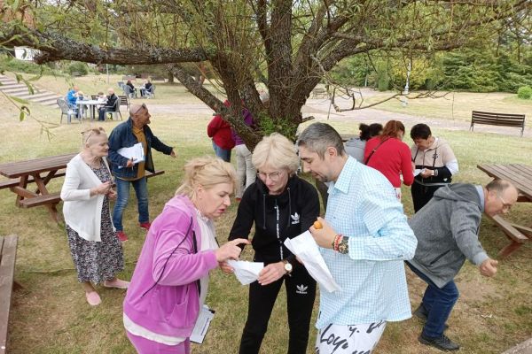 Uczestnicy pikniku grają w grę logiczną.
