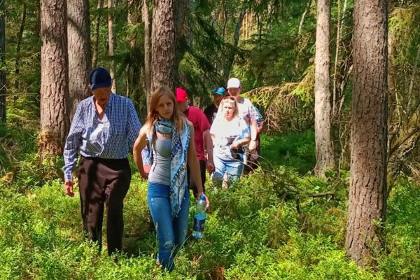 Mieszkańcy idą lasem.