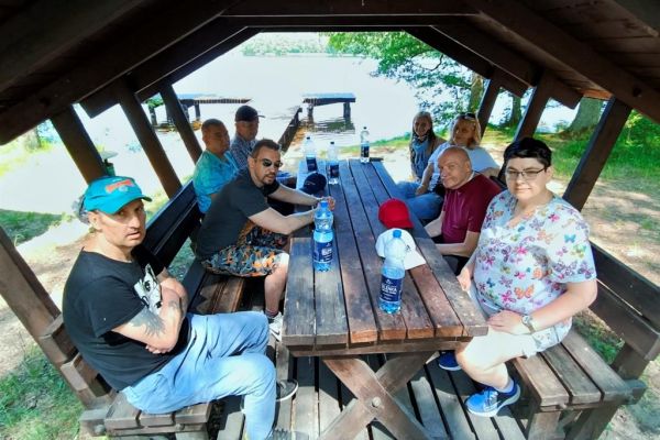 Mieszkańcy siedzą w pod wiata leśną.