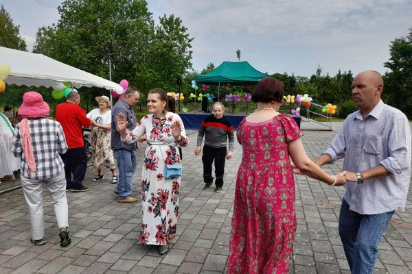 Mieszkańcy tańczą na pikniku wsród innych uczestników imprezy.