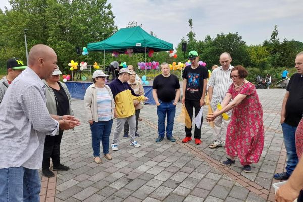 Mieszkańcy biorą udział w zabawie zręcznościowej wsród innych uczestników imprezy.