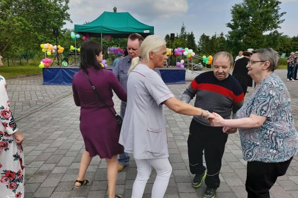 Mieszkańcy tańczą na pikniku wsród innych uczestników imprezy.