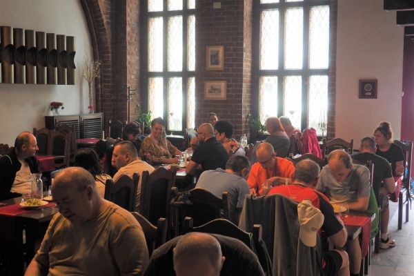 Mieszkańcy wraz z pracownikami domu w Toruniu jedza obiad w restauracji.
